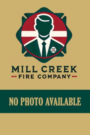 A placeholder image with a silhouette of a person in a suit, a badge on the lapel, and text reading "Mill Creek Fire Company" above "No Photo Available" on a tan background.
