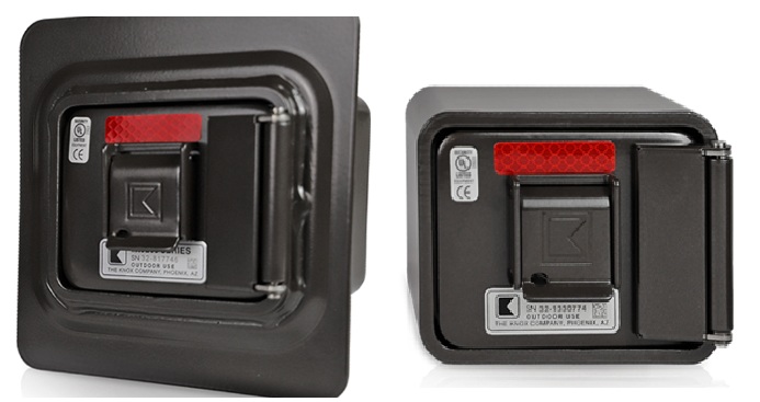 Two views of a black rectangular device with a red reflector, certification labels, and a metallic latch on its front. The device is mounted within a square frame and appears industrial.